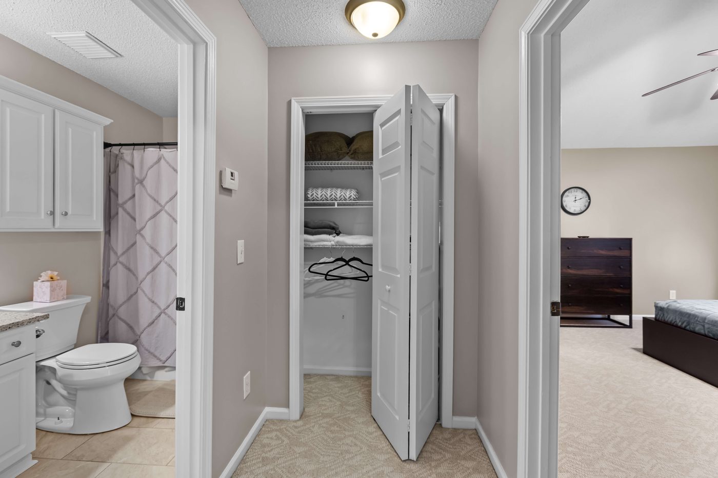 Hall linen closet flanked by the second full bathroom and a bedroom entry