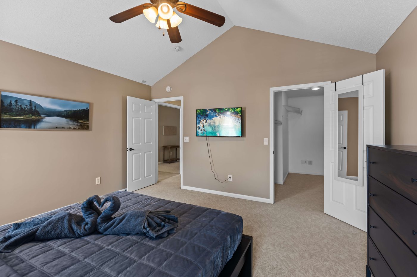 Second bedroom showing the double door entry, a wall mounted TV, and closet