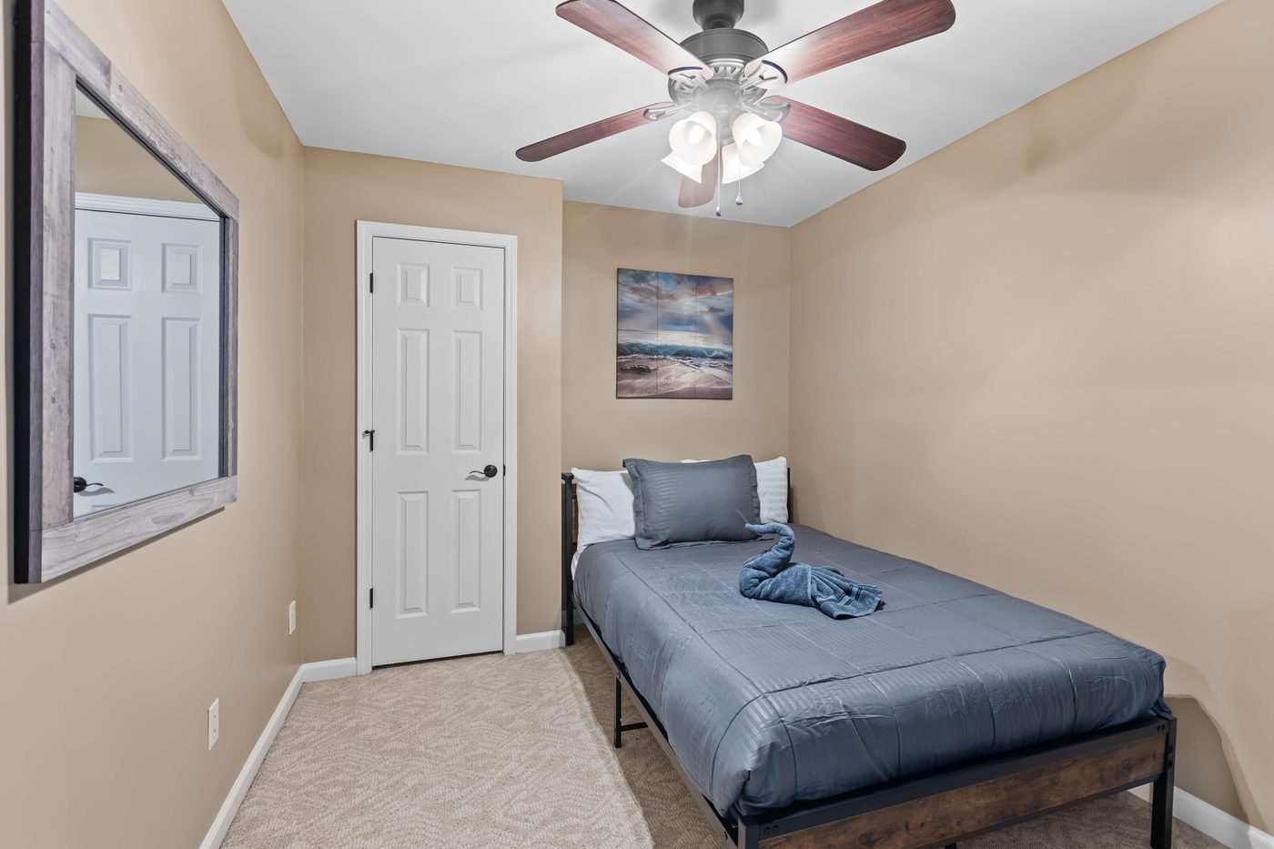 Third bedroom with a bed, a reach-in closet, and a framed wall mirror