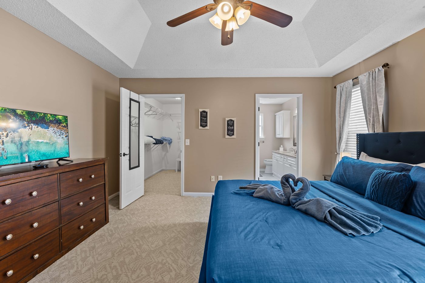 Primary bedroom showing the walk-in closet and the private ensuite bathroom entries