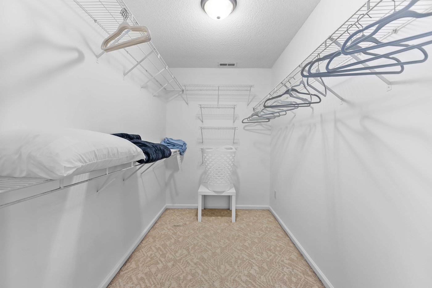 Primary walk-in closet with wire shelving and a tile floor