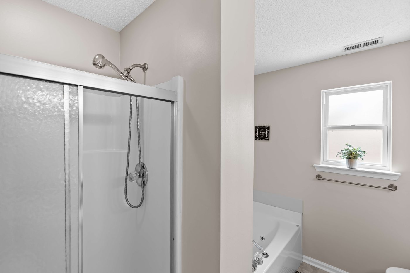 Primary ensuite bathroom with a glass enclosed shower and a jetted soaking tub