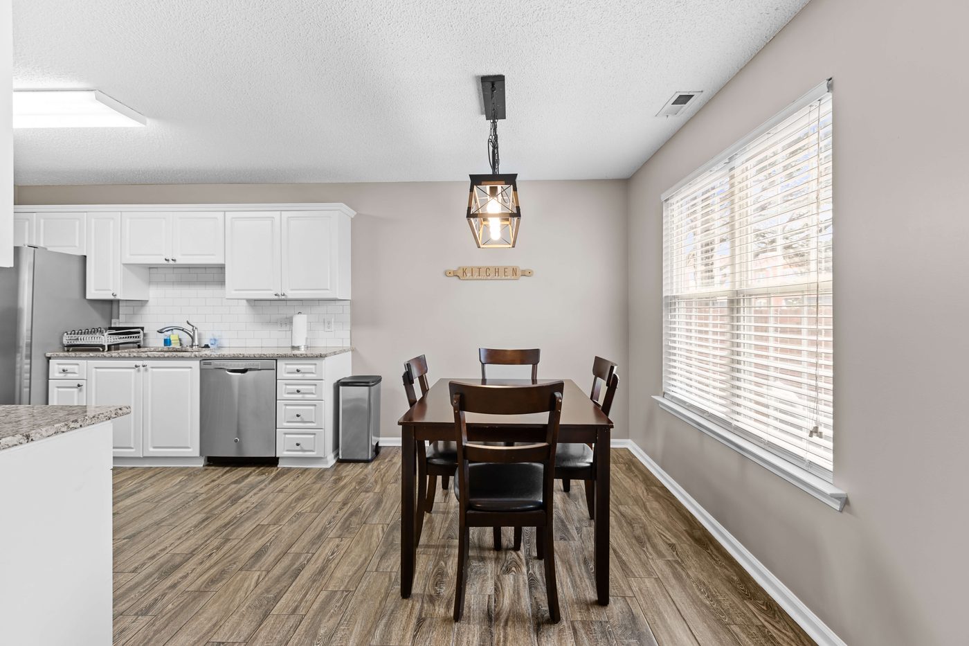 Dining area beside the kitchen with seating for four and a pendant light