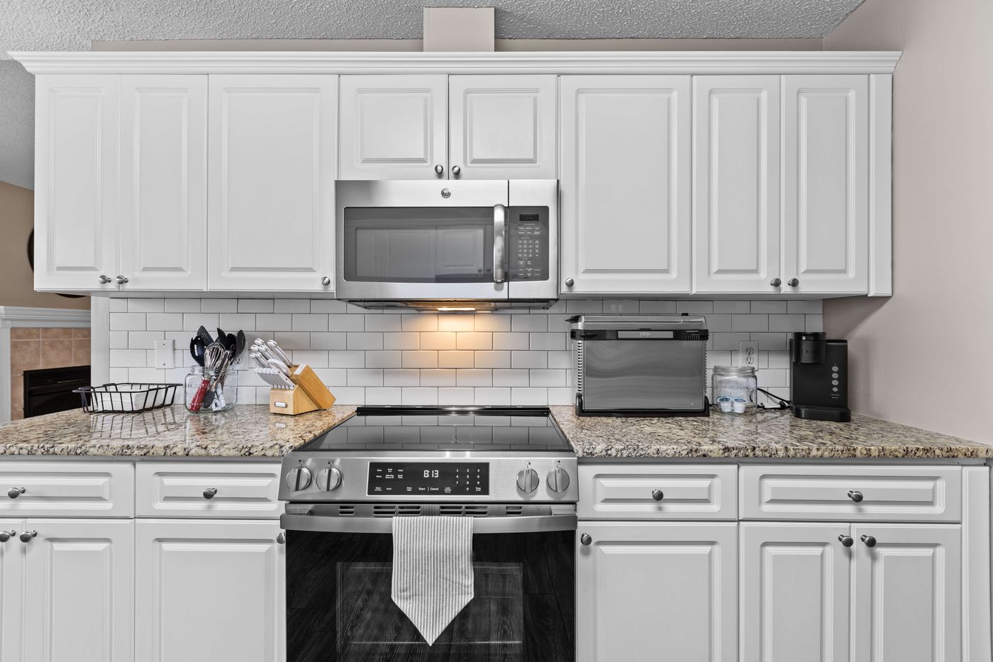 Kitchen range, microwave, and a subway tile backsplash